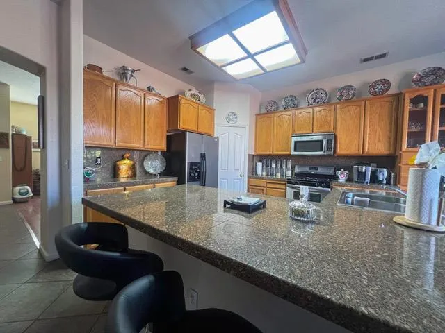 a kitchen with stainless steel appliances granite countertop a sink a stove and a microwave