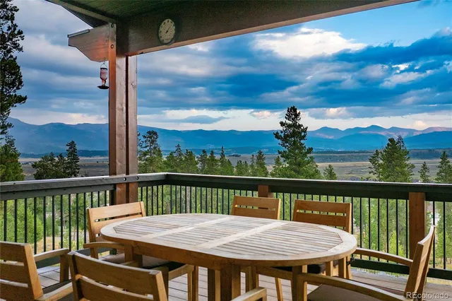 a view of a balcony with mountain view and wooden floor