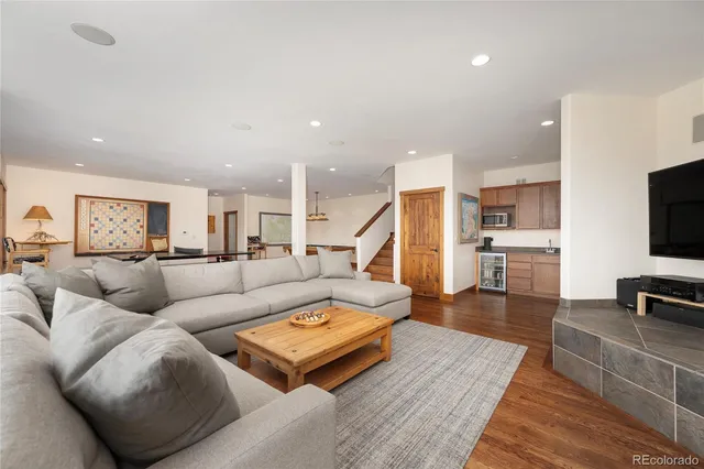 a living room with furniture a flat screen tv and a wooden floor