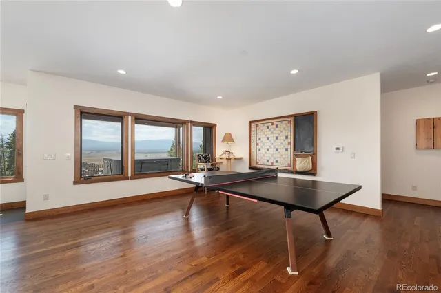 a view of a patio with table and chairs with wooden floor and fence