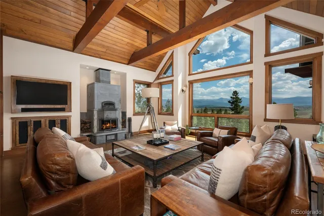 a living room with furniture a flat screen tv and a large window