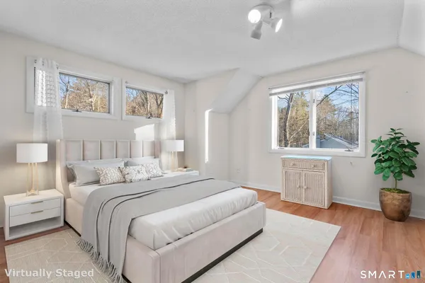 a bedroom with a large bed and a potted plant