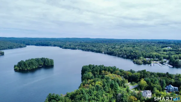 an aerial view of lake and residential houses with outdoor space