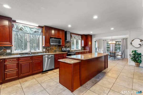 a large kitchen with stainless steel appliances granite countertop a large counter top and a stove top oven