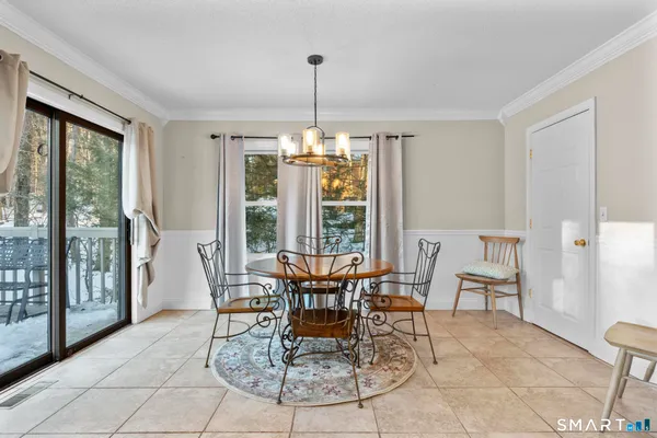 a dining room with furniture large windows and a chandelier
