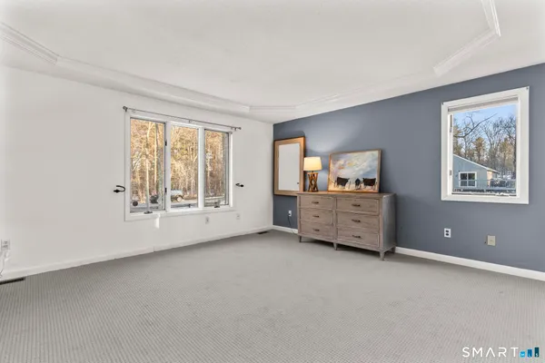 a view of an empty room with a window and a kitchen