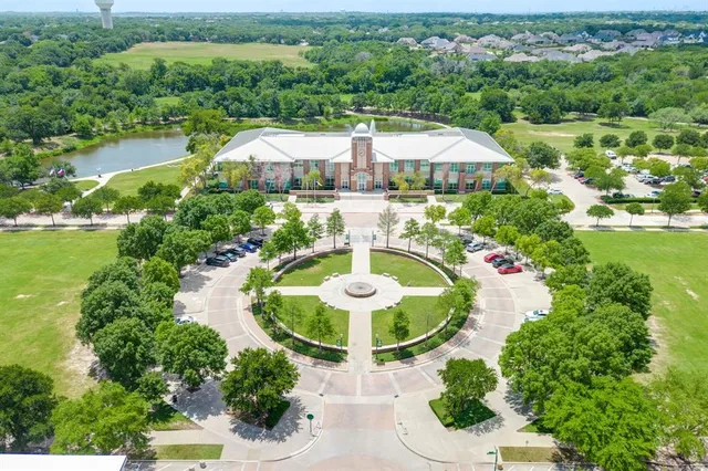 an aerial view of residential houses with outdoor space and trees