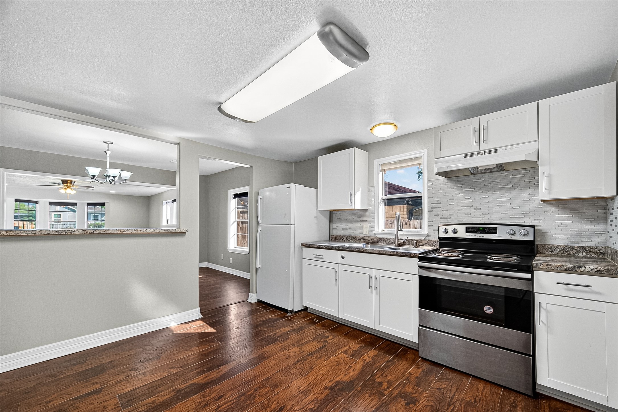 4034 Caplin Street Houston, TX 77026 - Photo 15 of 37 a kitchen with stainless steel appliances kitchen island granite countertop a stove top oven a sink and a refrigerator