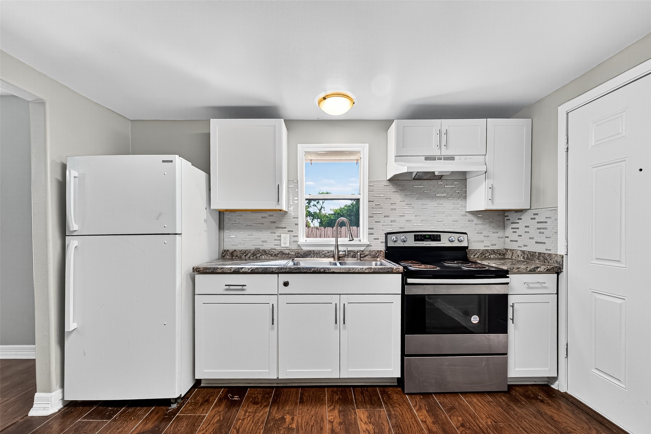 4034 Caplin Street Houston, TX 77026 - Photo 16 of 37 a kitchen with white cabinets and white appliances