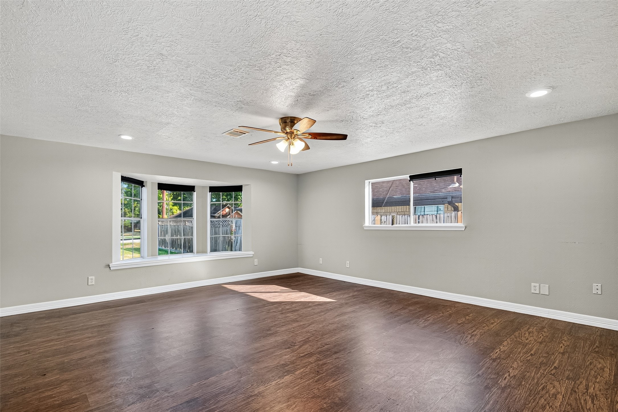 4034 Caplin Street Houston, TX 77026 - Photo 8 of 37 a view of an empty room with wooden floor and a window