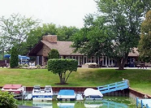 a view of house with garden space and car parked in the park