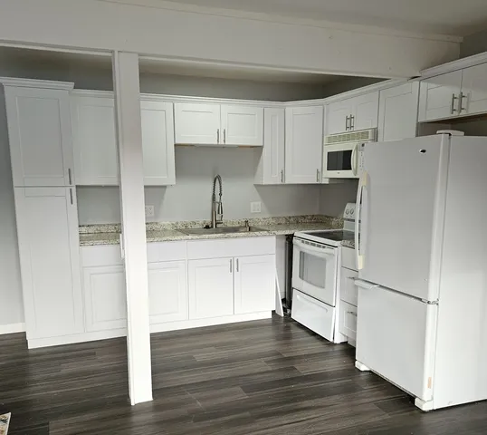 a kitchen with white cabinets and white appliances