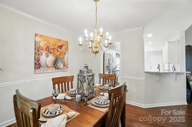a view of a dining room with furniture a chandelier and wooden floor