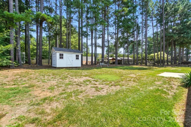 a view of a house with a big yard and large trees