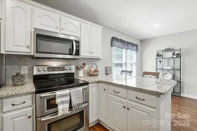 a kitchen with granite countertop a stove microwave and sink