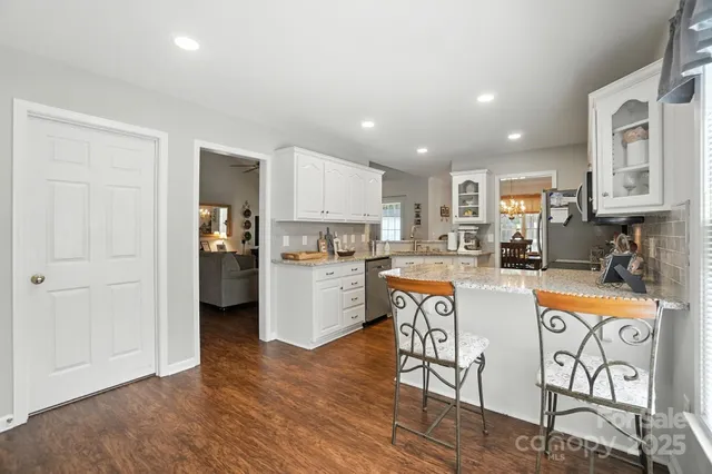 a kitchen with stainless steel appliances granite countertop a refrigerator and a stove top oven