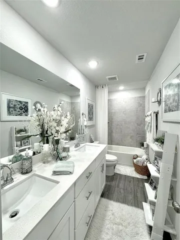 a large bathroom with double vanity sinks a large mirror and a shower