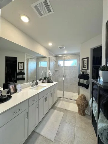 a large bathroom with a double vanity sink a mirror and shower