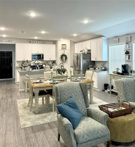 a living room with furniture and a view of kitchen