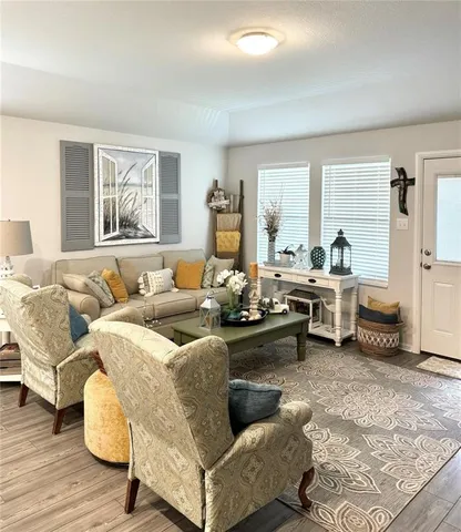 a living room with furniture and a wooden floor