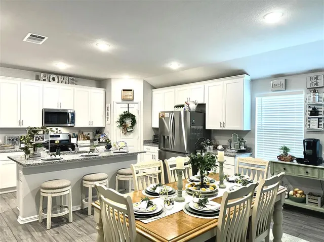 a living room with furniture flowerpot and wooden floor