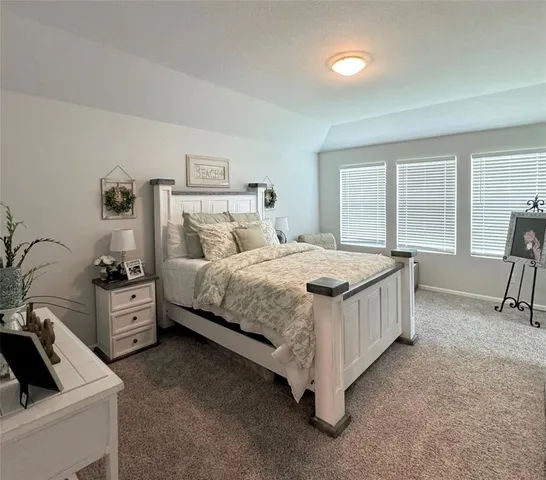 a bedroom with a bed and a large window