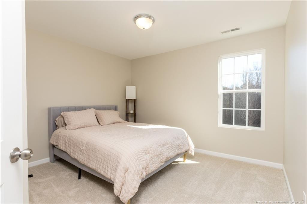 325 Ray Byrd Road Lillington, NC 27546 - Photo 16 of 26 a bedroom with a bed and a window