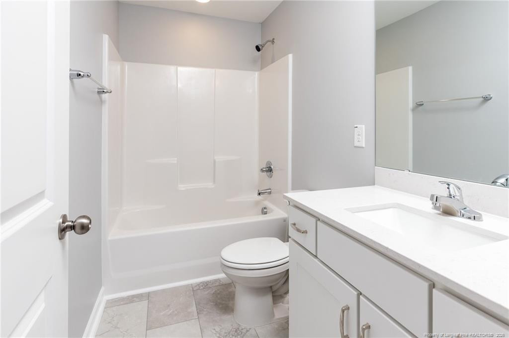 325 Ray Byrd Road Lillington, NC 27546 - Photo 18 of 26 a bathroom with a granite countertop sink a toilet and shower