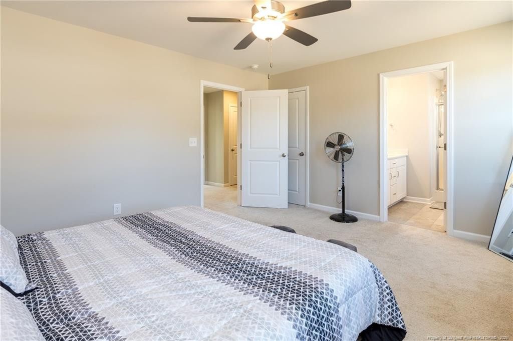 325 Ray Byrd Road Lillington, NC 27546 - Photo 20 of 26 a bedroom with a bed and a chandelier