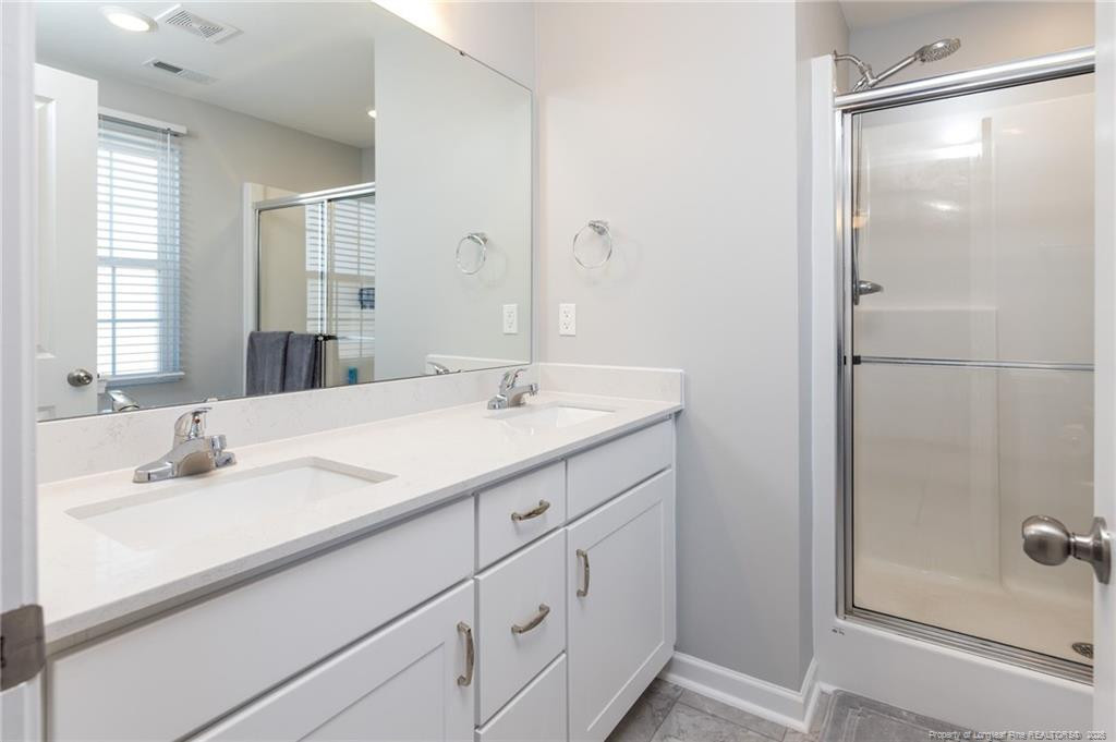 325 Ray Byrd Road Lillington, NC 27546 - Photo 21 of 26 a bathroom with a shower sink and mirror