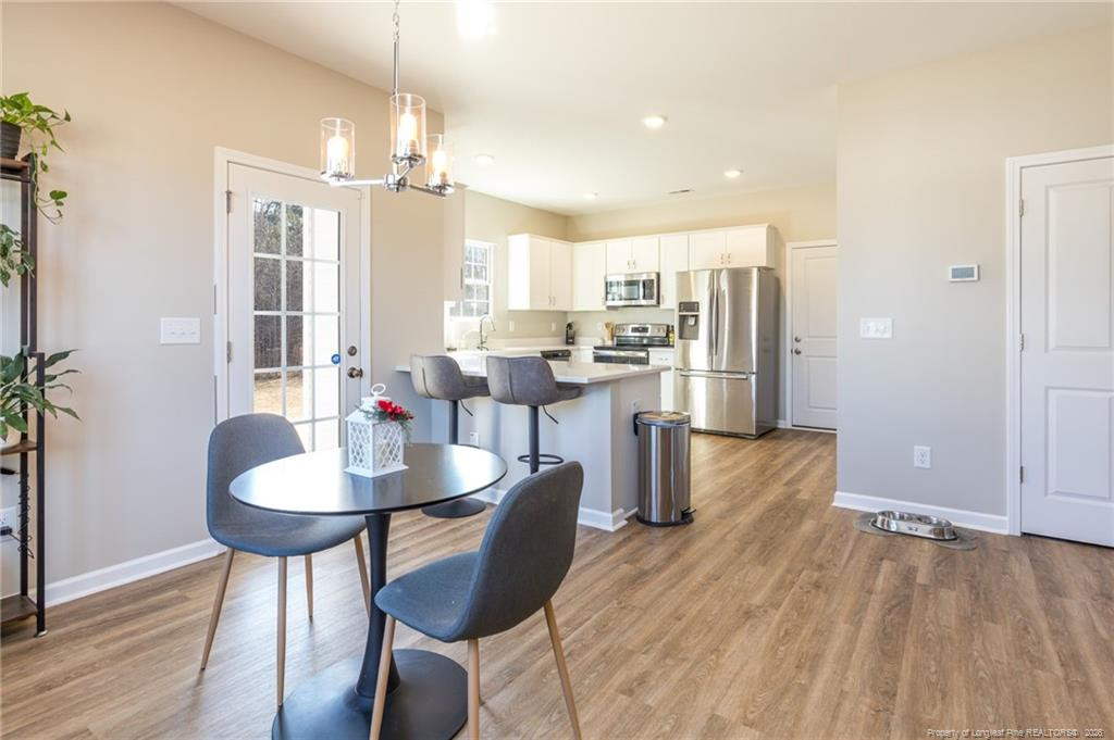 325 Ray Byrd Road Lillington, NC 27546 - Photo 5 of 26 a dining room with stainless steel appliances kitchen island granite countertop a table chairs and a refrigerator