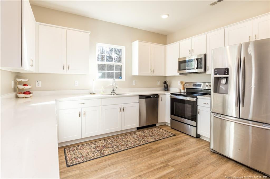 325 Ray Byrd Road Lillington, NC 27546 - Photo 8 of 26 a kitchen with a refrigerator stove and sink