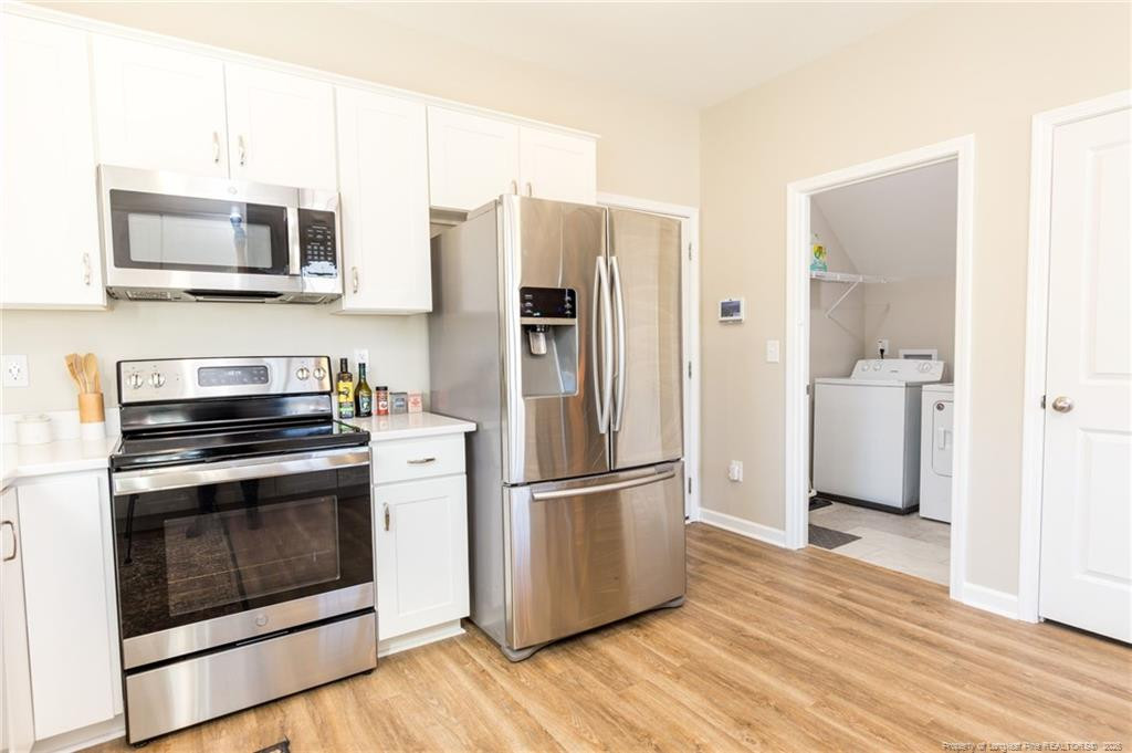 325 Ray Byrd Road Lillington, NC 27546 - Photo 9 of 26 a kitchen with stainless steel appliances a refrigerator microwave and sink