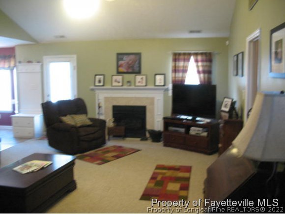 5324 Spreading Branch Road Hope Mills, NC 28348 - Photo 3 of 20 a living room with furniture a flat screen tv and a fireplace