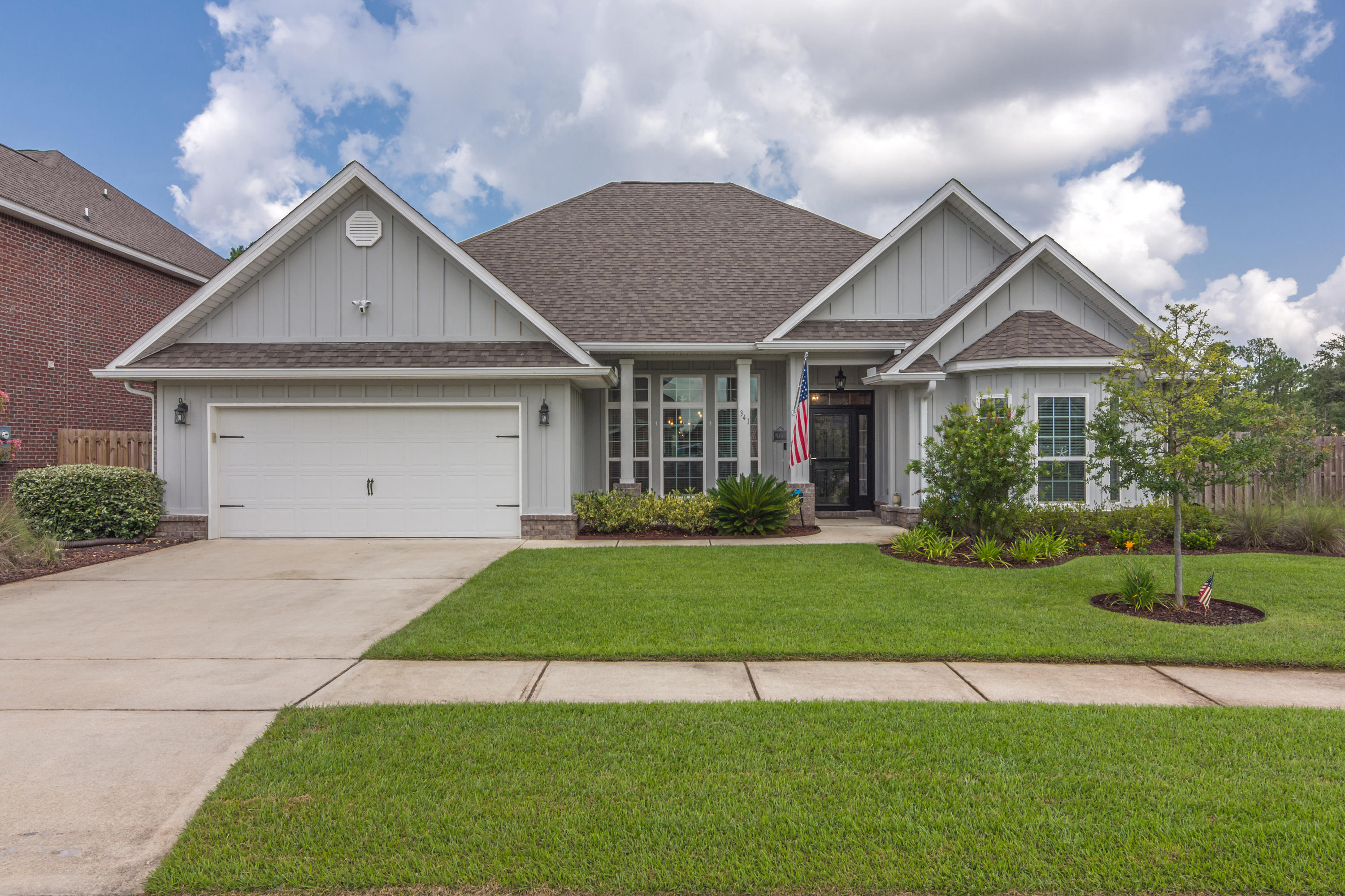 341 Lilly Bell Lane Freeport, FL 32439 - Photo 1 of 36 a front view of a house with a yard and garage