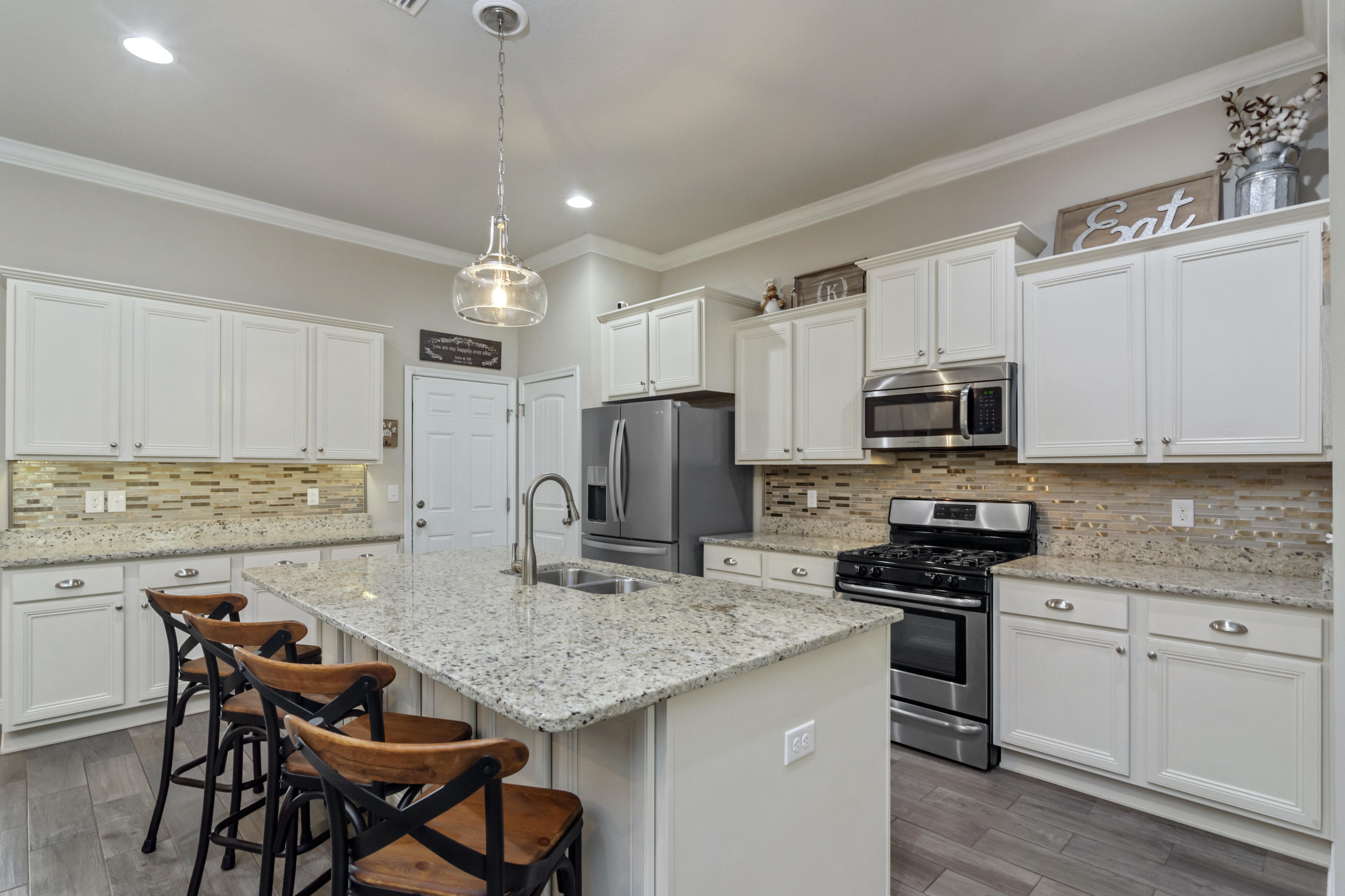341 Lilly Bell Lane Freeport, FL 32439 - Photo 13 of 36 a kitchen with stainless steel appliances granite countertop a stove top oven a refrigerator a sink and chairs