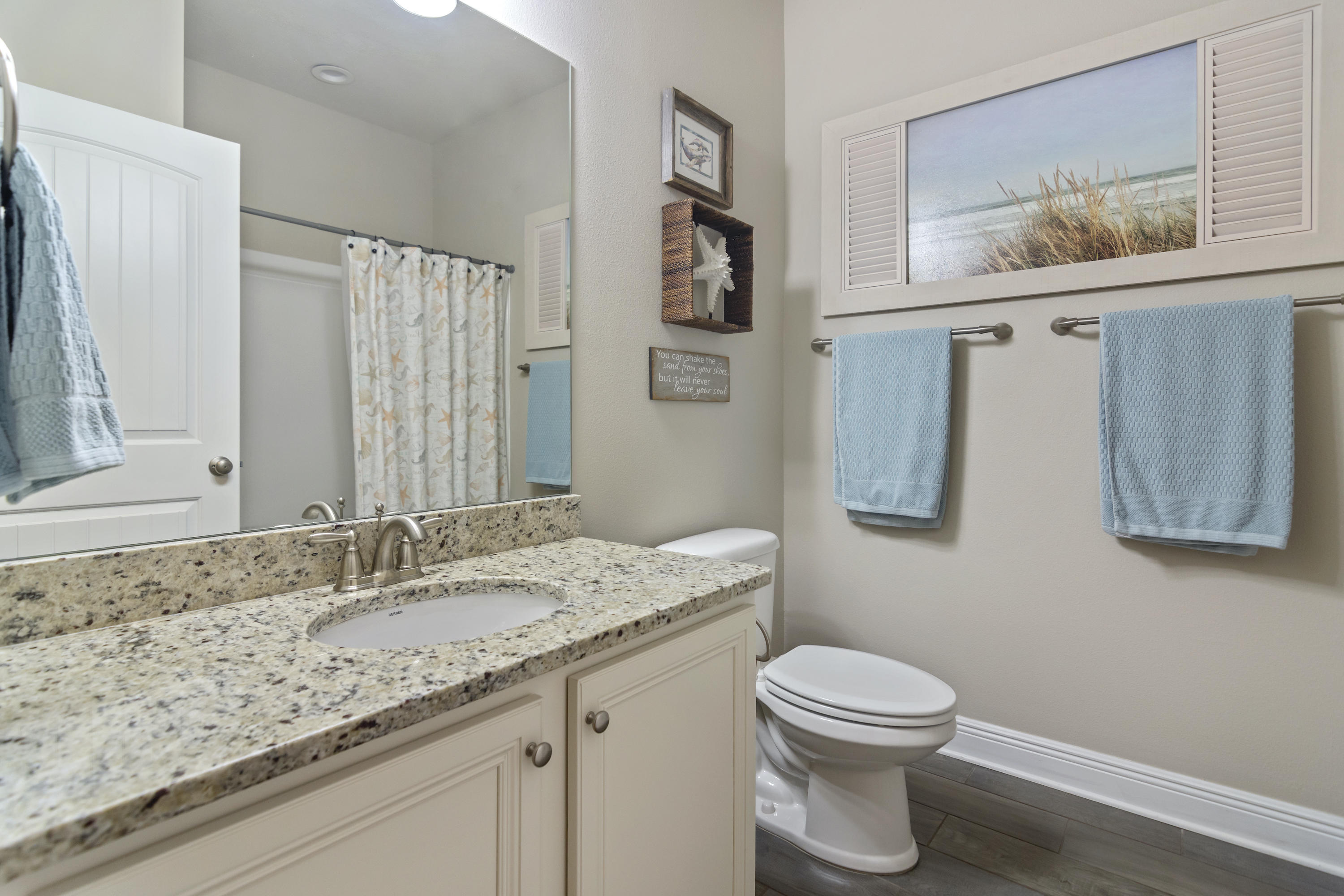 341 Lilly Bell Lane Freeport, FL 32439 - Photo 24 of 36 a bathroom with a granite countertop sink a toilet and a mirror