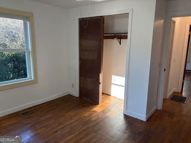 an empty room with wooden floor and a window