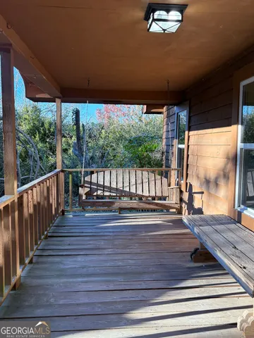 a view of deck with wooden floor and floor to ceiling windows