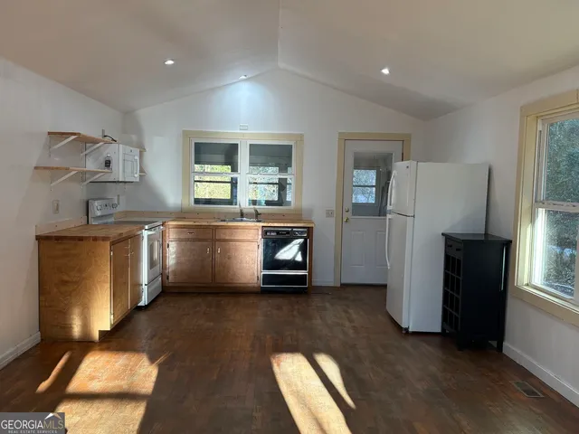 a kitchen with stainless steel appliances granite countertop a refrigerator a stove a sink and a microwave