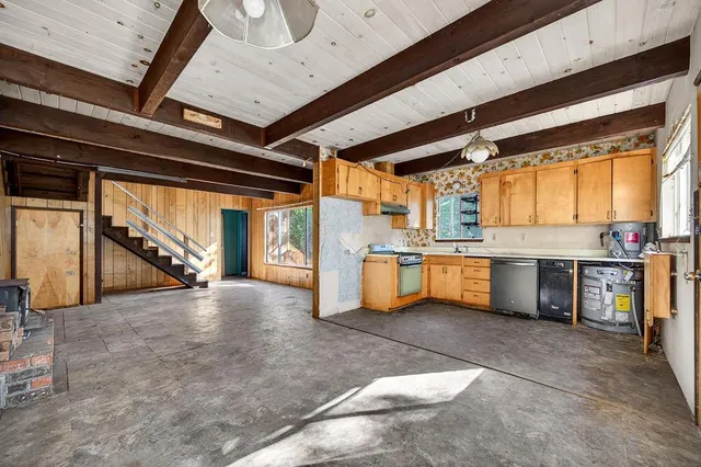 a kitchen with stainless steel appliances granite countertop a sink a stove and a wooden floors