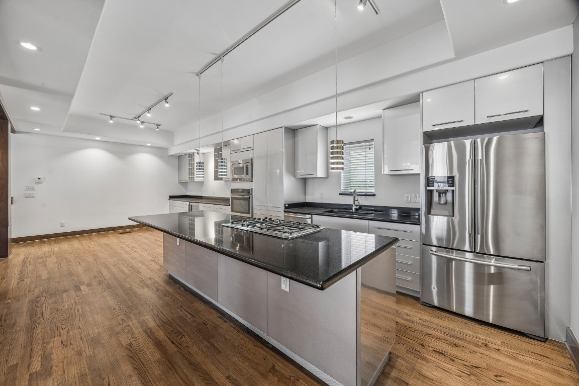 1820 Prospect Street Houston, TX 77004 - Photo 5 of 17 a kitchen with granite countertop a refrigerator and wooden floor