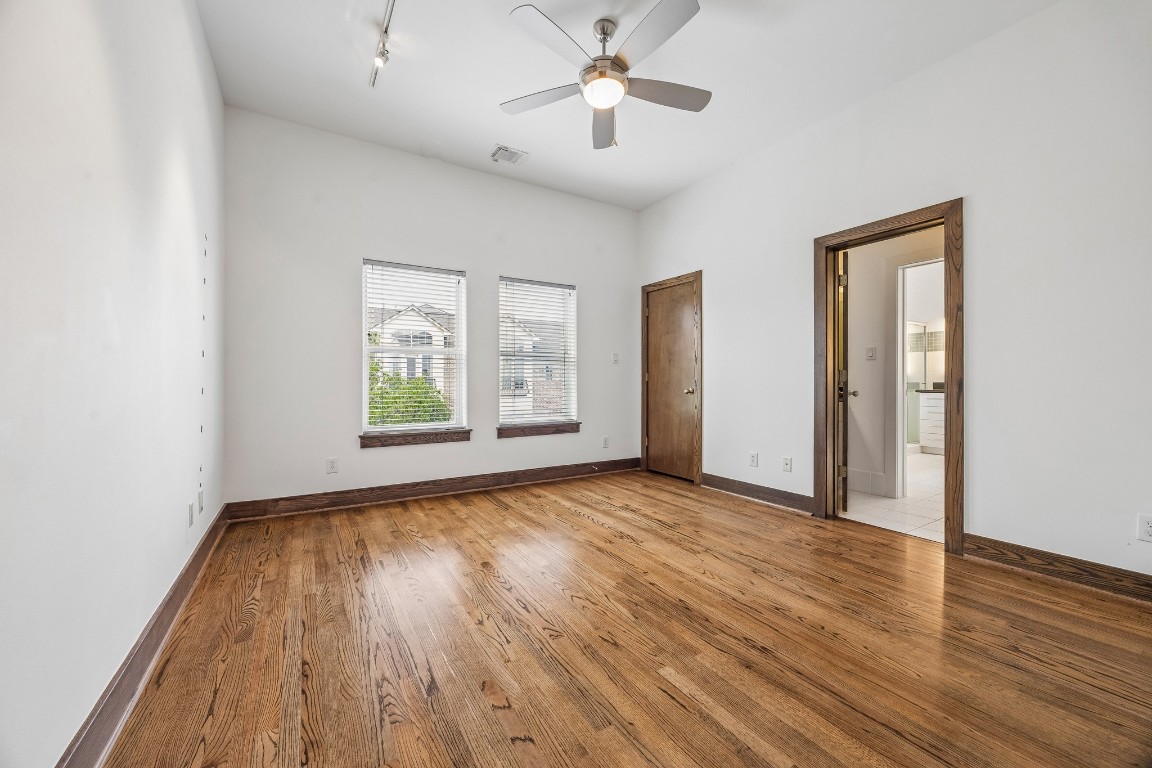 1820 Prospect Street Houston, TX 77004 - Photo 10 of 17 an empty room with wooden floor chandelier fan and windows