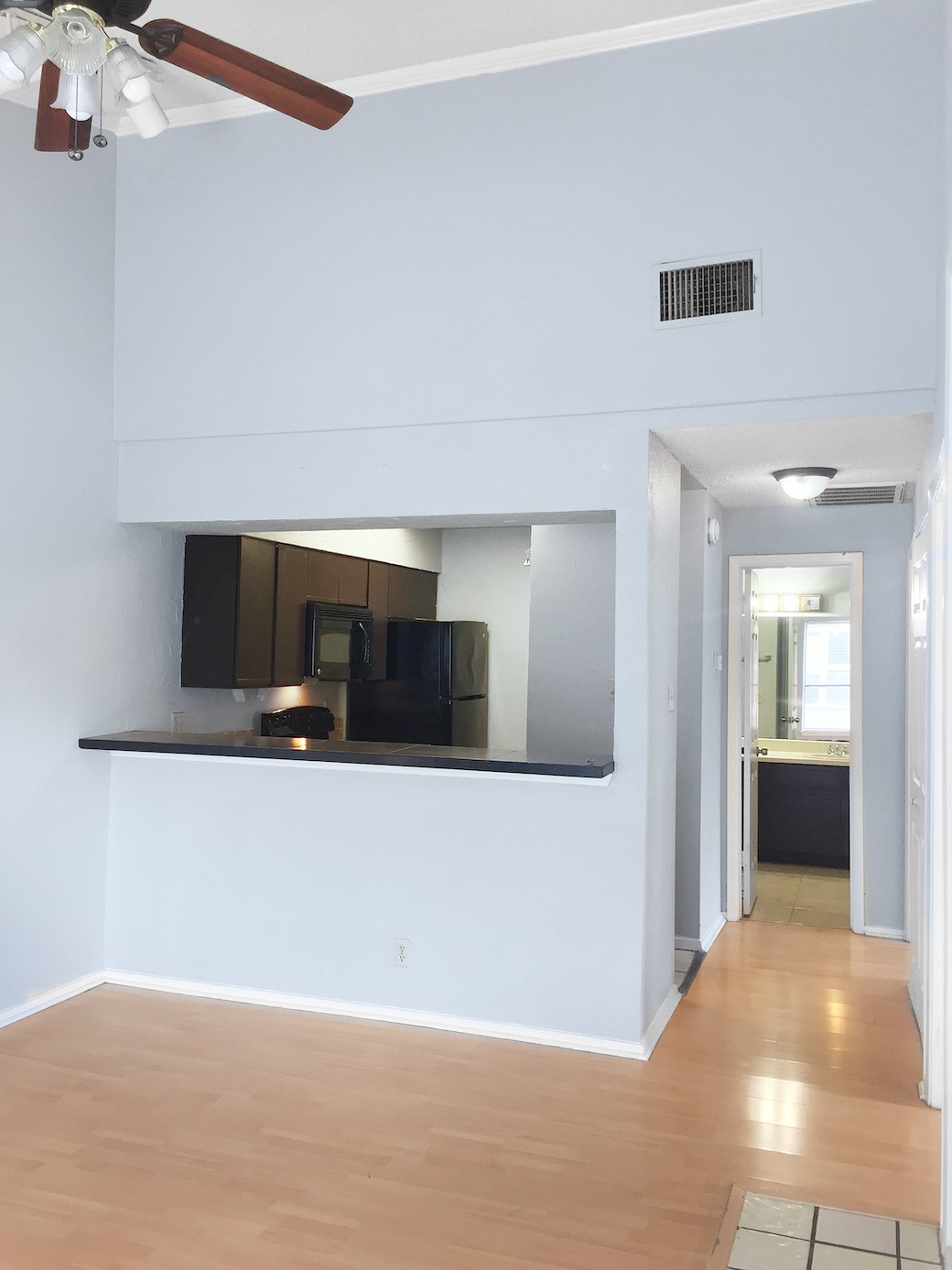 807 West 25th Street, Unit 312 Austin, TX 78705 - Photo 5 of 15 Unfurnished living room featuring ceiling fan, light wood-type flooring, and a high ceiling