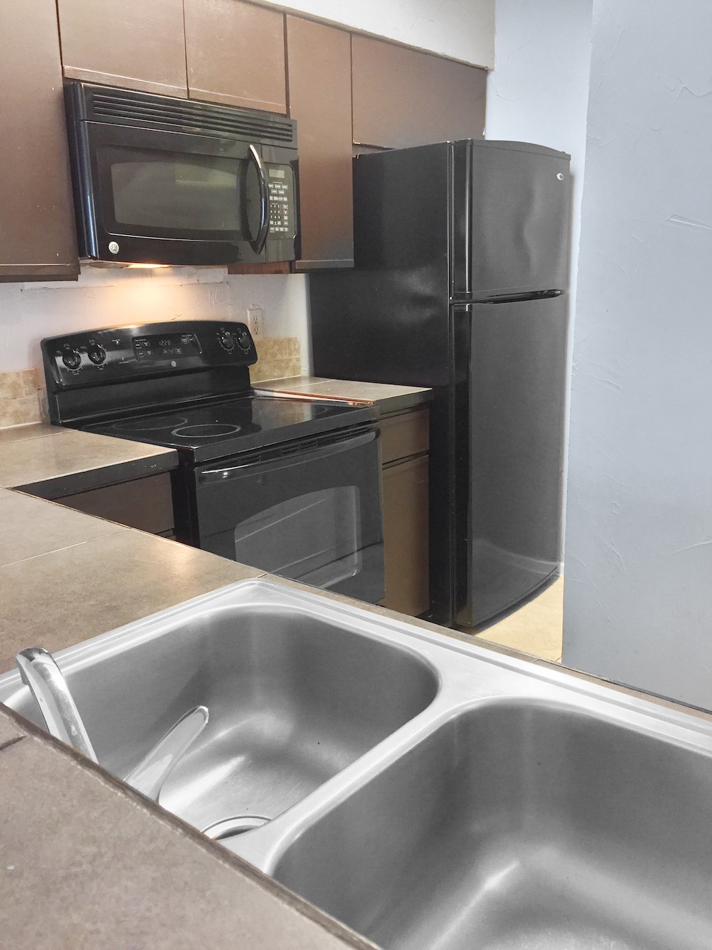 807 West 25th Street, Unit 312 Austin, TX 78705 - Photo 6 of 15 Kitchen with black appliances and light countertops