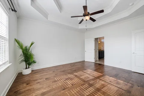 a view of room with a ceiling fan and wooden floor