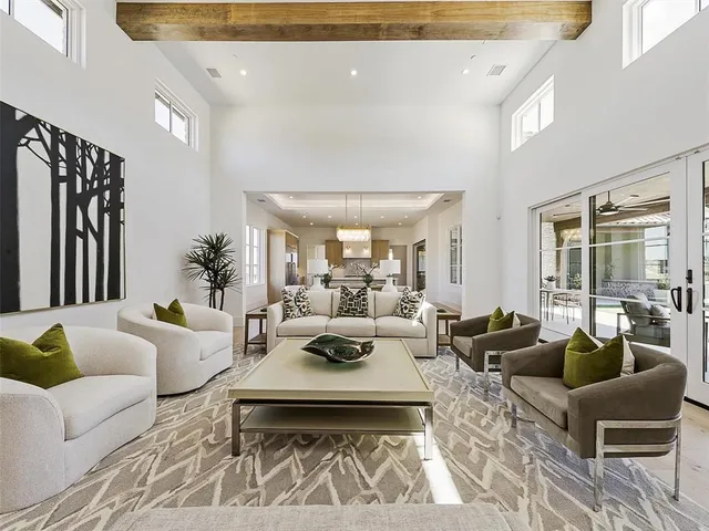 a living room with furniture potted plant and a large window