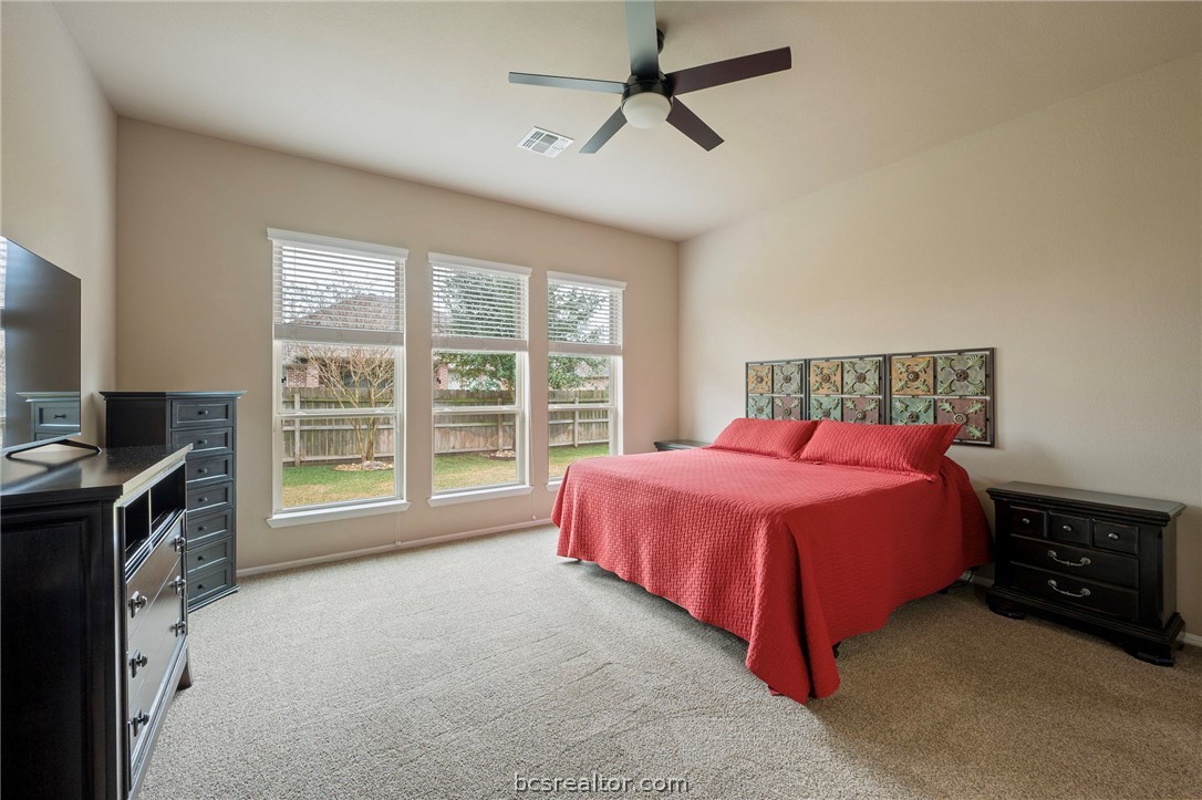 3085 Archer Circle Bryan, TX 77808 - Photo 14 of 32 Bedroom with light carpet, a ceiling fan, and abundant natural light.