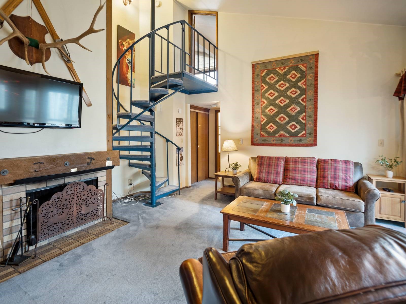 Carpeted living room featuring high vaulted ceiling