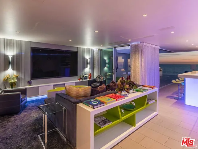 a living room with furniture kitchen view and a wooden floor